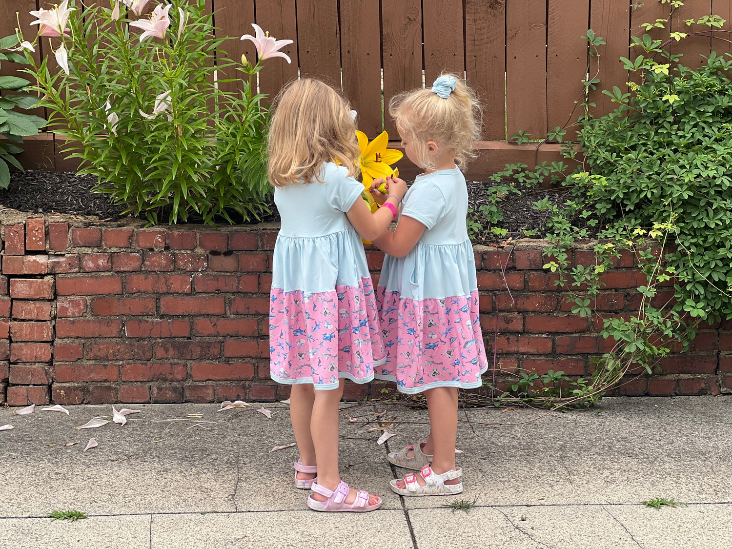Girls wearing soft cotton summer twirl dresses with colorful prints outdoors