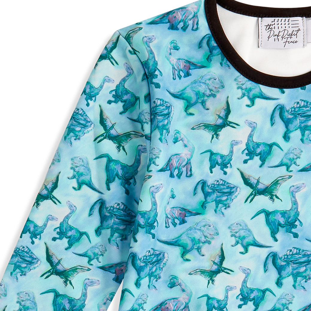Long-sleeve dress with dinosaur pattern on a light blue background
