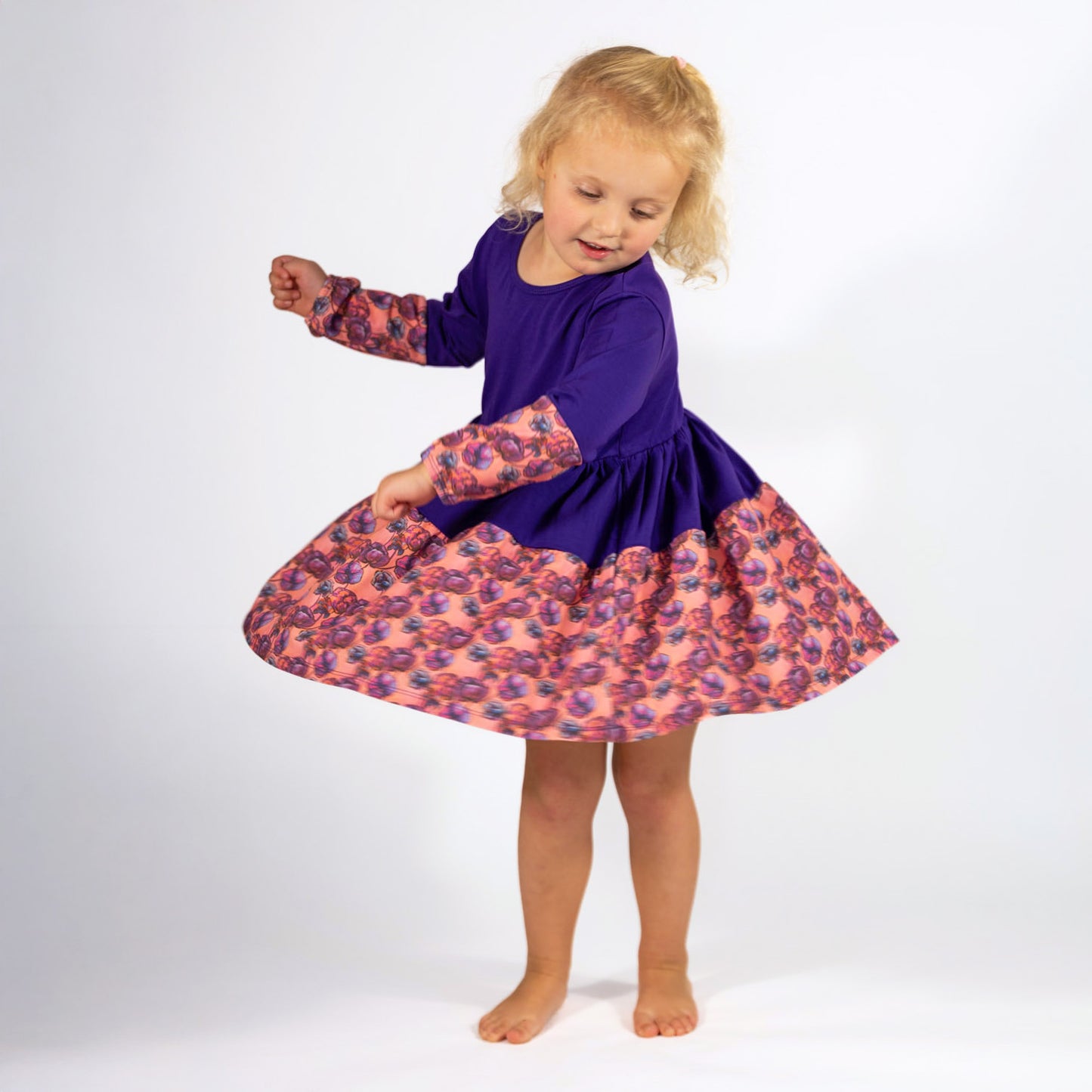 Twirly Girl Dresses - Toddler girl in motion wearing a purple twirl dress; handmade long sleeve dress by The Pink Picket Fence