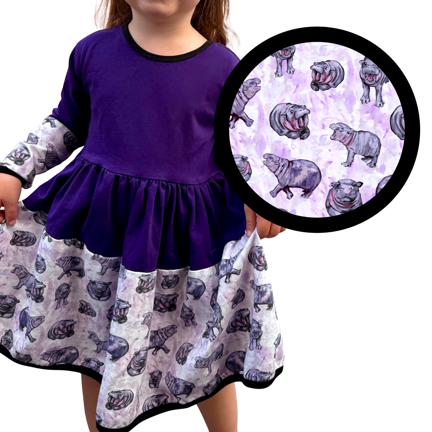 Child wearing a purple dress with hippo pattern, close-up of pattern on white background
