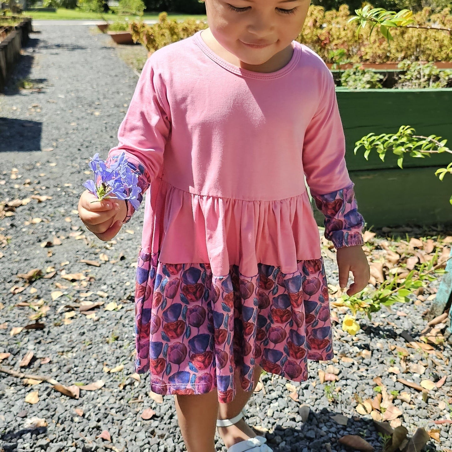 Toddler girl wearing a pink organic cotton twirl dress; soft and playful design for girls ages 2–6 by The Pink Picket Fence