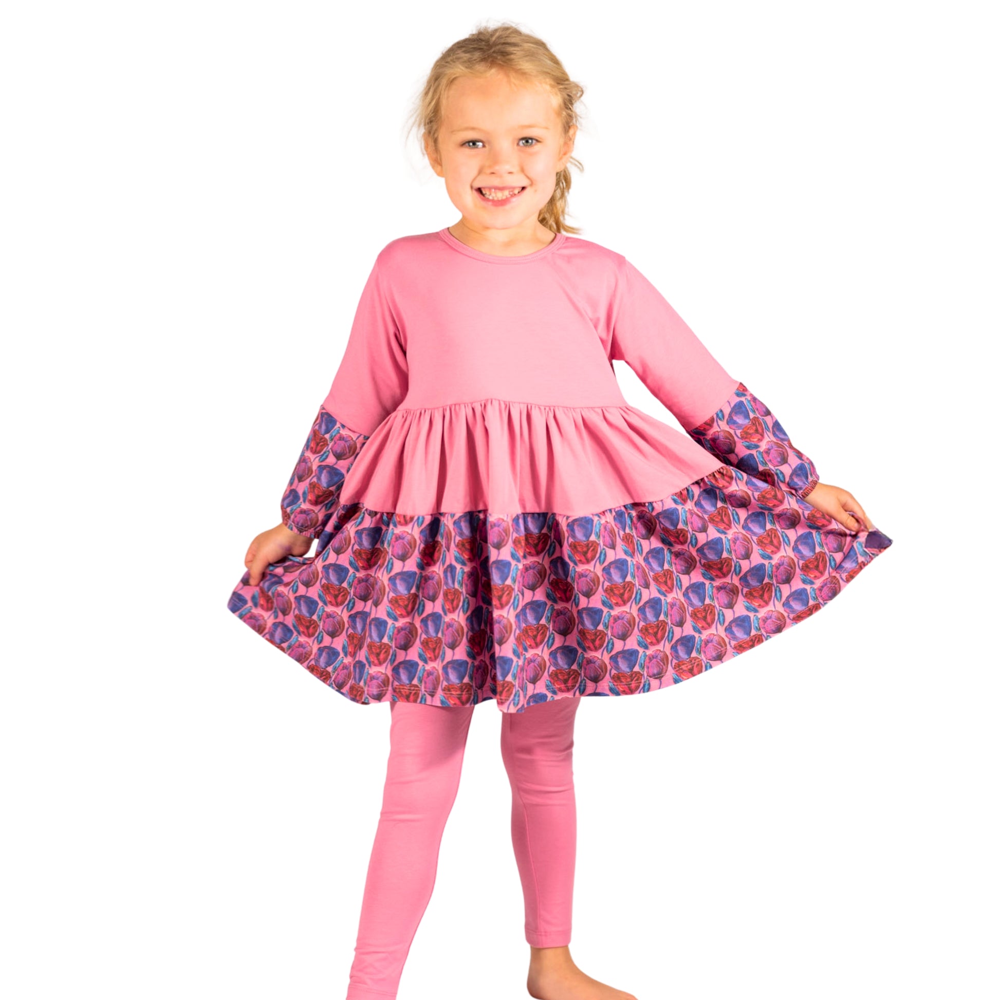 Pink floral cotton twirl dress worn by a young girl; full skirt and long sleeves designed for movement