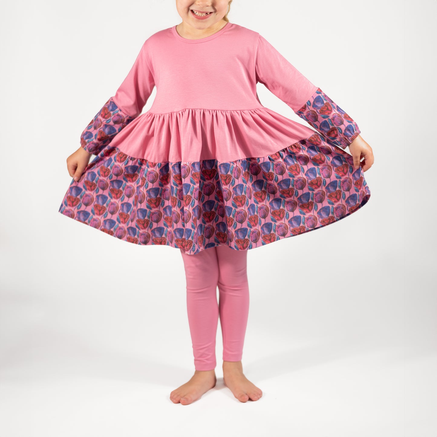 Overhead view of twirl dress in pink floral pattern with full skirt and long sleeves; handmade toddler dress