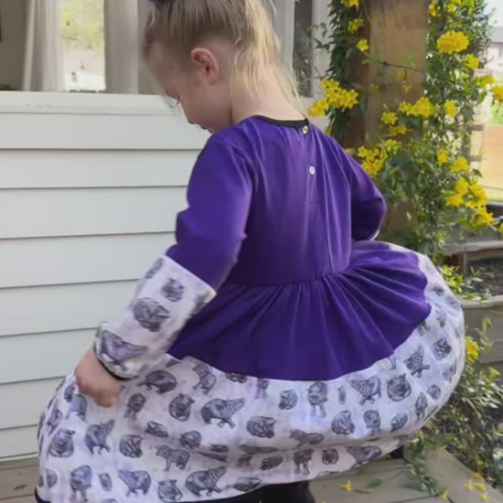 Sisters dancing in matching purple hippo dresses, made for twirling and everyday play.