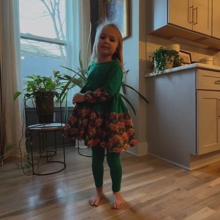 Toddler girl spinning in the Green Louise Twirl Dress; organic cotton outfit for girls ages 2–6